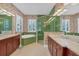 Bright bathroom featuring dual sinks, a glass shower, a soaking tub, and beautiful, patterned wallpaper at 603 Harbor Shore Dr, Nokomis, FL 34275