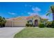 Charming single-story home with a tile roof, lush landscaping, and an attached three-car garage at 644 Rivendell Blvd, Osprey, FL 34229