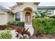 Close-up of an arched doorway with sidelights and lush landscaping surrounding the front entrance at 644 Rivendell Blvd, Osprey, FL 34229