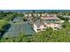 An aerial view of yellow townhouses near tennis courts and with ocean view at 653 Cedars Ct, Longboat Key, FL 34228