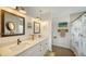 Dual-sink bathroom boasts shiplap, modern fixtures, framed mirrors, and a walk-in shower at 653 Cedars Ct, Longboat Key, FL 34228