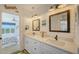 Primary bathroom features dual sinks with stone countertops, modern lighting, and access to the bedroom at 653 Cedars Ct, Longboat Key, FL 34228