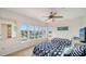 Bright guest bedroom with two beds, carpeting, a ceiling fan, and windows overlooking the pool at 653 Cedars Ct, Longboat Key, FL 34228