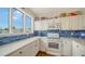 Bright kitchen boasts white cabinetry, subway tile backsplash, stainless appliances, and coastal decor at 653 Cedars Ct, Longboat Key, FL 34228