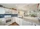 Modern kitchen with white cabinets, stainless steel appliances and stylish backsplash at 653 Cedars Ct, Longboat Key, FL 34228
