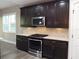 A kitchen featuring dark cabinetry, stainless steel appliances, and white countertops at 7486 Divot Loop # 7486, Bradenton, FL 34202