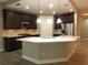 A kitchen featuring dark cabinetry, stainless steel appliances, and a large center island with white countertops at 7486 Divot Loop # 7486, Bradenton, FL 34202