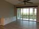 An empty living room features a bank of sliding glass doors and a built in cabinet with ample storage at 7486 Divot Loop # 7486, Bradenton, FL 34202