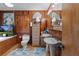 Wood paneled bathroom with dual sinks, bathtub, and wicker accents at 39200 Cook Brown Rd, Punta Gorda, FL 33982