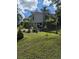 Home on stilts sits in grassy yard with mature trees at 39200 Cook Brown Rd, Punta Gorda, FL 33982
