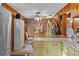 Cozy kitchen with wood paneling and retro appliances next to a dining area at 39200 Cook Brown Rd, Punta Gorda, FL 33982
