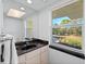 Bathroom with black granite countertop, updated fixtures, and a window with a garden view at 4191 Strombus Rd, Venice, FL 34293