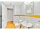 Bright bathroom boasts pedestal sink, white cabinetry, and wood floors for a clean, classic look at 514 Riverside E Dr, Bradenton, FL 34208