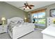 Light-filled bedroom with lake view, ceiling fan, and white furniture at 5281 Mahogany Run Ave # 822, Sarasota, FL 34241