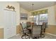 Cozy dining area featuring a glass table, four chairs, and a sunlit window with decorative valance at 5281 Mahogany Run Ave # 822, Sarasota, FL 34241