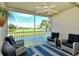 Enclosed lanai with wicker furniture overlooking a scenic golf course and lake at 5281 Mahogany Run Ave # 822, Sarasota, FL 34241
