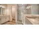 Modern bathroom featuring a glass enclosed shower, double vanity with stone countertops and white cabinetry at 7668 Registrar Way, Sarasota, FL 34243