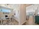 Bright hallway leading to an office space with wood floors and an open-concept kitchen and living area at 7668 Registrar Way, Sarasota, FL 34243