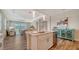 Open kitchen with island, stainless appliances, granite counters, and a view of the dining and living areas at 7668 Registrar Way, Sarasota, FL 34243