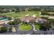 Aerial view showcasing the clubhouse, golf course, pool, and beautifully landscaped grounds of the community at 8737 Pebble Creek Ln, Sarasota, FL 34238