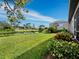 Beautifully landscaped backyard view of pond and screened in pool at 8737 Pebble Creek Ln, Sarasota, FL 34238
