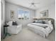 Cozy bedroom with a comfortable bed, white armchair, and a large window providing natural light and views at 8737 Pebble Creek Ln, Sarasota, FL 34238