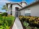 Attractive home showcasing a screened entryway, manicured landscaping, and a well-maintained walkway at 8737 Pebble Creek Ln, Sarasota, FL 34238