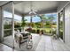 Relaxing sunroom with comfortable seating, tile flooring, and a picturesque view of the surrounding landscape and pond at 8737 Pebble Creek Ln, Sarasota, FL 34238