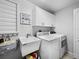 Laundry room features washer, dryer, sink, storage cabinets, and hanging rack at 8737 Pebble Creek Ln, Sarasota, FL 34238
