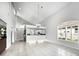 Open-concept living room with tile flooring, vaulted ceilings, and window shutters at 8737 Pebble Creek Ln, Sarasota, FL 34238