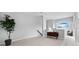 Spacious loft area with neutral carpeting and a large arched window letting in lots of natural light at 8737 Pebble Creek Ln, Sarasota, FL 34238