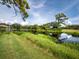 Scenic pond view with lush greenery and trees reflecting in the water, creating a serene and picturesque setting at 8737 Pebble Creek Ln, Sarasota, FL 34238