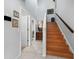 Well-lit staircase with wooden steps and a white railing, complemented by neutral wall colors and tiled flooring at 8737 Pebble Creek Ln, Sarasota, FL 34238
