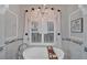 Beautiful bathroom with a modern soaking tub, marble tiling, and a decorative window at 11432 Savannah Lakes Dr, Parrish, FL 34219