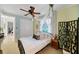 Light-filled bedroom with a ceiling fan, canopy, and large window with white shutters at 11432 Savannah Lakes Dr, Parrish, FL 34219
