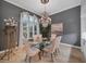 Elegant dining room featuring gray walls, tile flooring, chandelier, and a glass-top table at 11432 Savannah Lakes Dr, Parrish, FL 34219