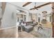 Spacious living room with stylish gray sofa and a large window and sliding door to the outdoors at 11432 Savannah Lakes Dr, Parrish, FL 34219