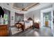 Main bedroom featuring a tray ceiling, hardwood floors, a four-poster bed, and views of the backyard at 11432 Savannah Lakes Dr, Parrish, FL 34219