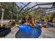 Screened-in pool area with beautiful blue lighting and a lush tropical oasis at 11432 Savannah Lakes Dr, Parrish, FL 34219