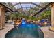 Stunning screened pool with waterfalls, lush greenery, and elegant lighting for evening enjoyment at 11432 Savannah Lakes Dr, Parrish, FL 34219
