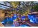 Covered pool area featuring a rock waterfall feature with underwater lights and tropical plants at 11432 Savannah Lakes Dr, Parrish, FL 34219