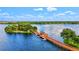 Picturesque aerial view of a lake with a wooden pier and gazebo, surrounded by lush greenery at 130 Riviera Dunes Way # 1104, Palmetto, FL 34221