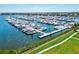 Aerial view of a boat-filled marina with waterfront condominiums, lush green spaces, and waterfront at 130 Riviera Dunes Way # 1104, Palmetto, FL 34221