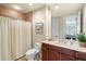 Comfortable bathroom featuring a decorative shower curtain, marble counters, and modern fixtures at 130 Riviera Dunes Way # 1104, Palmetto, FL 34221
