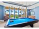 Bright game room featuring a blue pool table and scenic outdoor views at 130 Riviera Dunes Way # 1104, Palmetto, FL 34221