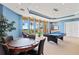 Fun game room features a pool table, card table, and comfortable seating with beautiful outside view at 130 Riviera Dunes Way # 1104, Palmetto, FL 34221
