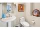 Elegant powder room featuring a pedestal sink, framed art, and a decorative wall sculpture at 130 Riviera Dunes Way # 1104, Palmetto, FL 34221