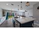Open-concept kitchen with an island, modern lighting, and seamless flow into the living area at 15404 Trinity Fall Way, Bradenton, FL 34212