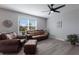 Comfortable living room with wood-look floors, a ceiling fan, and ample natural light at 15404 Trinity Fall Way, Bradenton, FL 34212