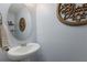 Stylish powder room featuring a round mirror and decorative wall art at 15404 Trinity Fall Way, Bradenton, FL 34212